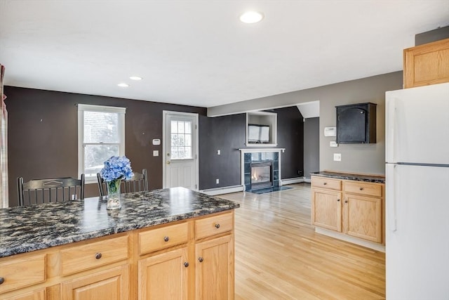105 Edgewater Dr W, Falmouth, MA 02536 - kitchen with a fireplace, freestanding refrigerator, light wood-style flooring, and light brown cabinetry