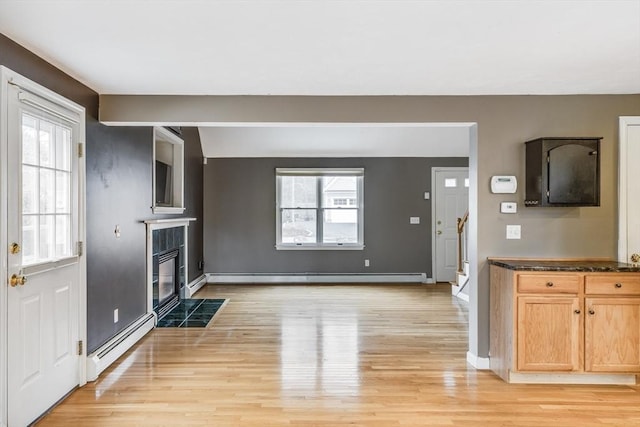 105 Edgewater Dr W, Falmouth, MA 02536 - unfurnished living room featuring a baseboard radiator, a fireplace with flush hearth, a baseboard heating unit, and plenty of natural light