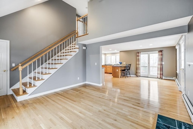 105 Edgewater Dr W, Falmouth, MA 02536 - unfurnished living room featuring a baseboard radiator, stairs, light wood finished floors, baseboards, and recessed lighting