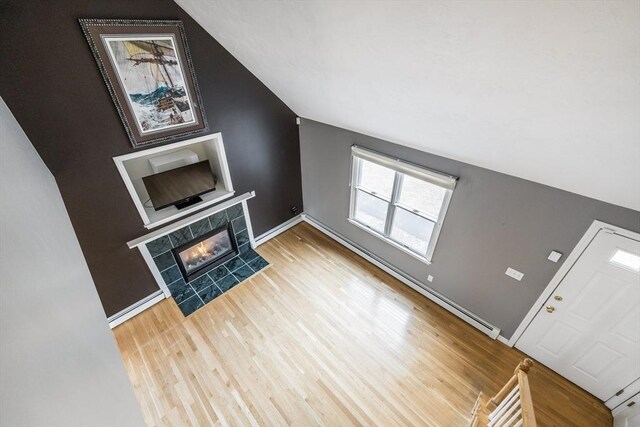 105 Edgewater Dr W, Falmouth, MA 02536 - unfurnished living room featuring lofted ceiling, baseboards, a tiled fireplace, and wood finished floors