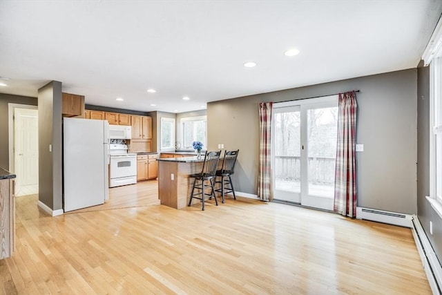 105 Edgewater Dr W, Falmouth, MA 02536 - kitchen featuring recessed lighting, white appliances, a peninsula, a kitchen bar, and light wood-style flooring