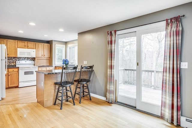 105 Edgewater Dr W, Falmouth, MA 02536 - kitchen with a peninsula, white appliances, a wealth of natural light, and light wood-style floors