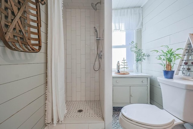 bathroom with a shower with curtain, toilet, and wood walls