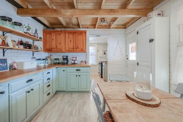 kitchen featuring wooden ceiling, wood counters, stainless steel gas range, beamed ceiling, and light wood-type flooring