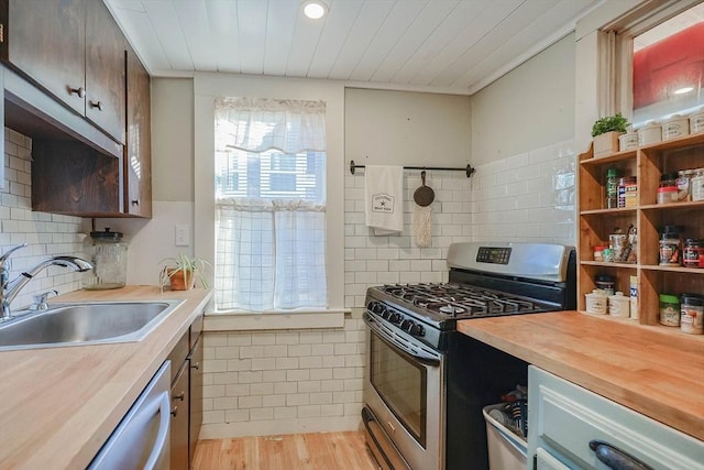 kitchen with light hardwood / wood-style floors, sink, wooden counters, and appliances with stainless steel finishes