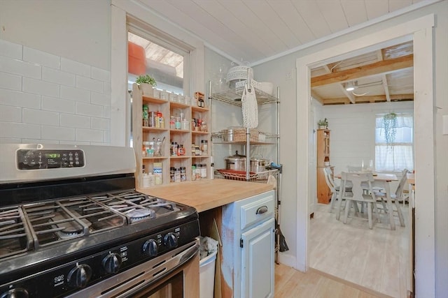 kitchen with wood counters, gas stove, light hardwood / wood-style floors, and crown molding