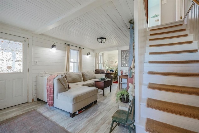 living room featuring beamed ceiling and light hardwood / wood-style floors