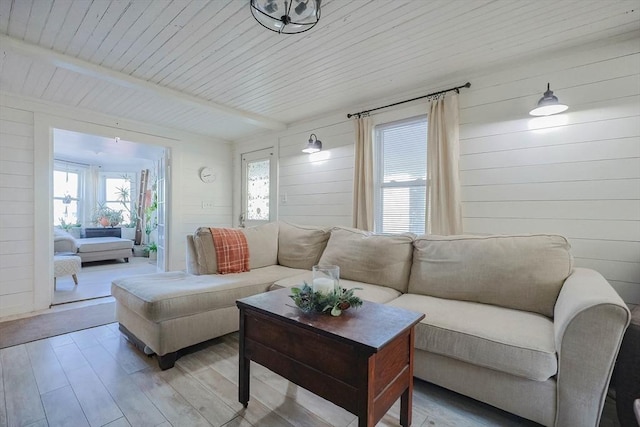 living room with wooden walls, beamed ceiling, and wood ceiling