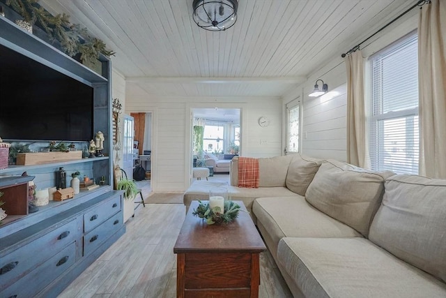 living room with beamed ceiling, wood walls, light wood-type flooring, and wood ceiling