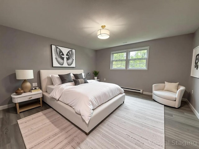 bedroom featuring baseboards, baseboard heating, and wood finished floors
