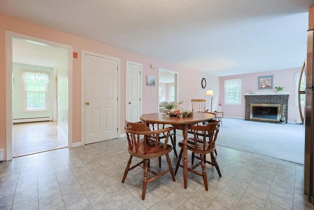 119 Messenger St, Plainville, MA 02762 - dining room featuring baseboard heating, a fireplace, baseboards, and light carpet