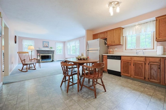 119 Messenger St, Plainville, MA 02762 - kitchen with white appliances, plenty of natural light, a brick fireplace, and light countertops