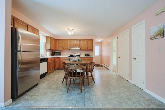 119 Messenger St, Plainville, MA 02762 - kitchen with stainless steel appliances, baseboard heating, under cabinet range hood, brown cabinets, and light countertops
