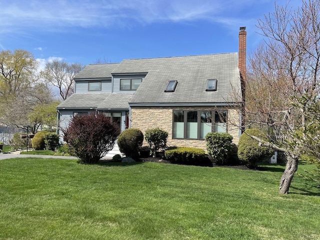 16 Howard Ave, Wells, ME 04090 - view of front facade with stone siding, a front yard, a chimney, and a shingled roof