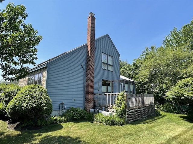 16 Howard Ave, Wells, ME 04090 - view of home's exterior featuring a lawn, a chimney, and a deck