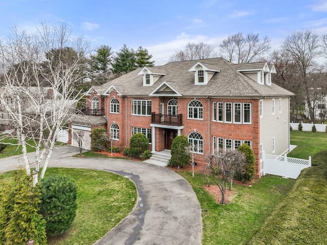 view of front of home with a balcony and a front lawn