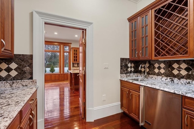 bar featuring backsplash, dark hardwood / wood-style flooring, crown molding, and sink