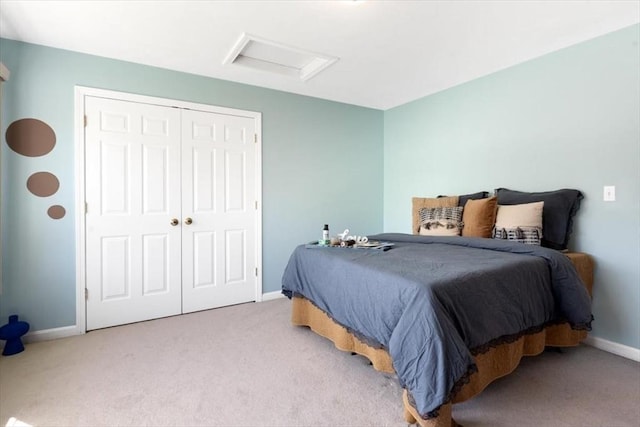 carpeted bedroom featuring baseboards, attic access, and a closet