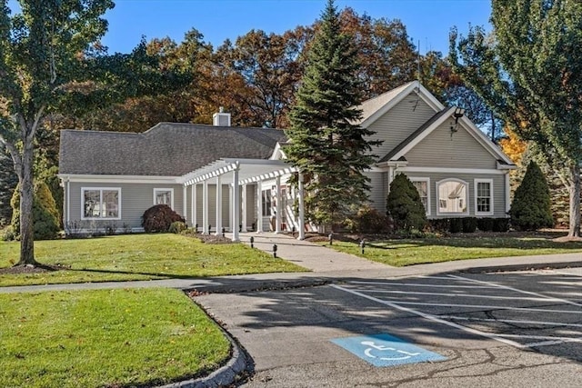 view of front of home featuring a pergola, uncovered parking, and a front lawn