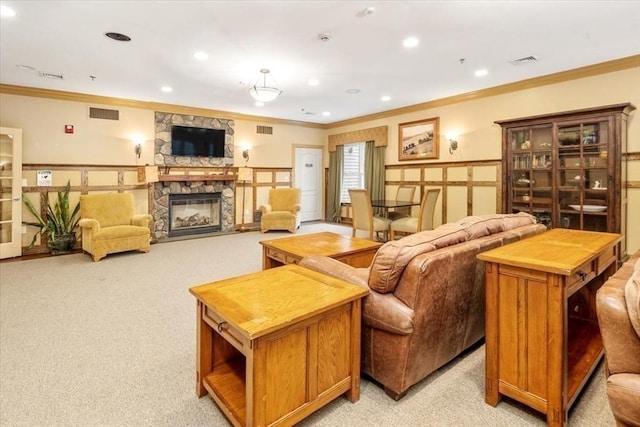 living area featuring ornamental molding, a fireplace, visible vents, and light colored carpet