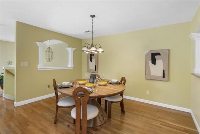dining area featuring baseboards, a notable chandelier, and wood finished floors