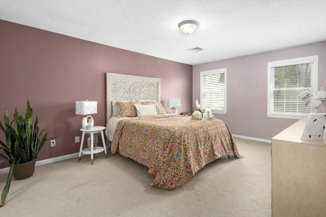 bedroom featuring baseboards, light carpet, and visible vents
