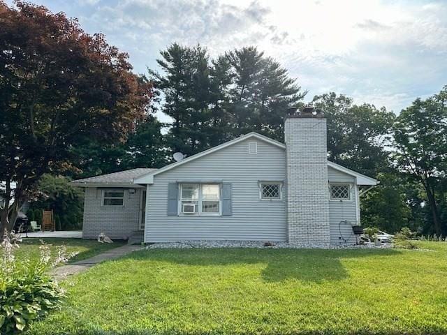 rear view of property featuring a lawn