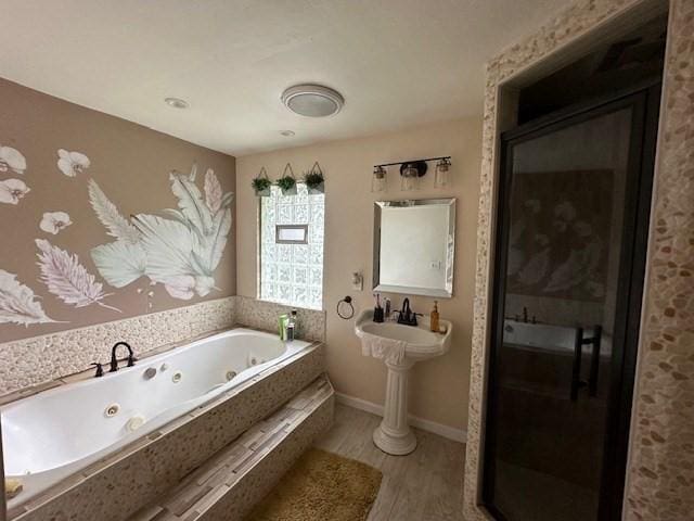 bathroom featuring hardwood / wood-style flooring and tiled bath