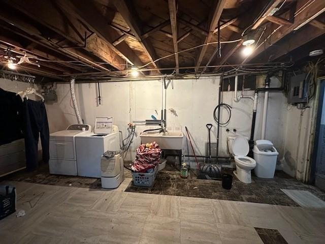 basement with electric panel, separate washer and dryer, and sink