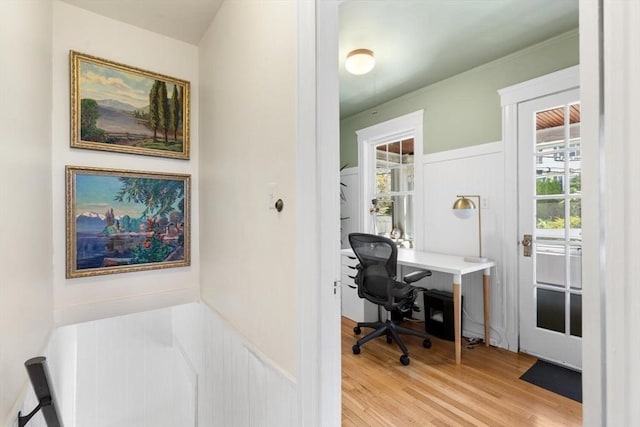 office with a decorative wall, wainscoting, and light wood-style floors