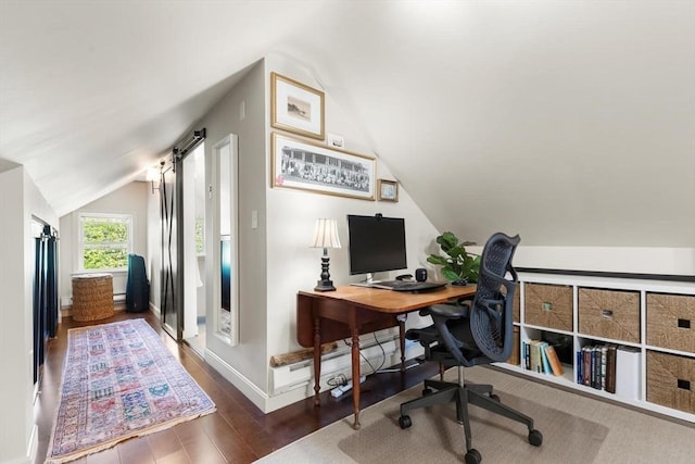 office area featuring baseboards, vaulted ceiling, and wood finished floors
