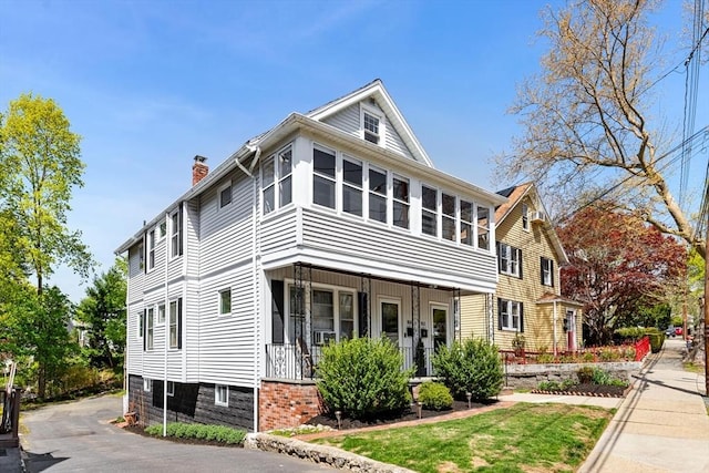 view of front of property featuring covered porch and a chimney