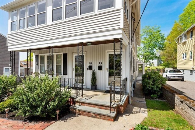 doorway to property with a porch and board and batten siding