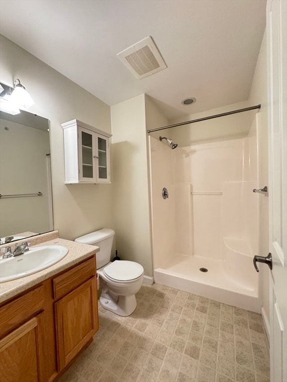 bathroom featuring a shower, vanity, and toilet