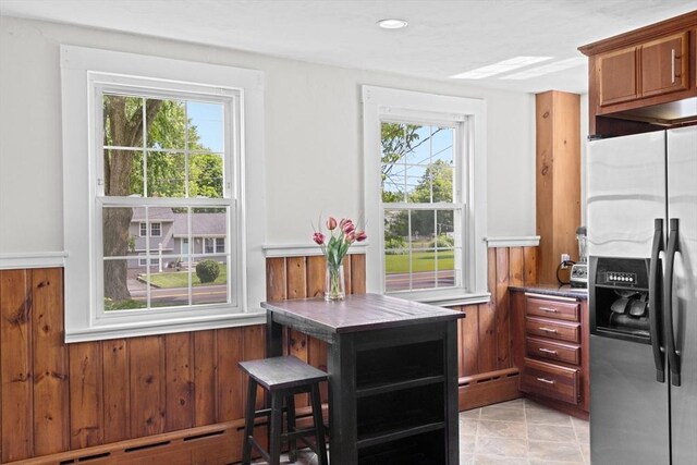 553 Center St, Hanover, MA 02339 - kitchen featuring stainless steel refrigerator with ice dispenser, wainscoting, wood walls, a baseboard heating unit, and brown cabinets
