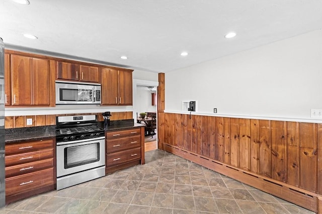 553 Center St, Hanover, MA 02339 - kitchen featuring appliances with stainless steel finishes, a baseboard heating unit, a wainscoted wall, dark countertops, and recessed lighting