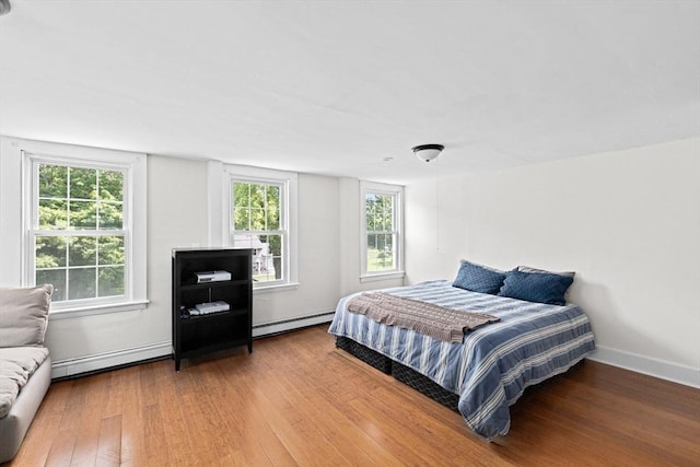 553 Center St, Hanover, MA 02339 - bedroom with wood finished floors, a baseboard heating unit, multiple windows, and a baseboard radiator