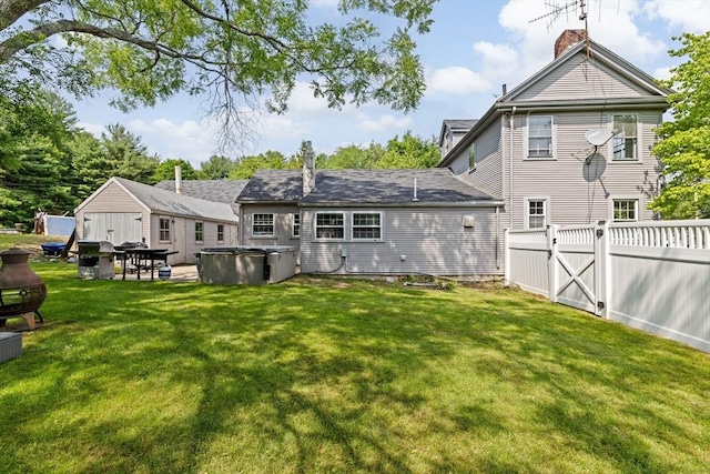 553 Center St, Hanover, MA 02339 - back of property with a hot tub, a chimney, and a patio