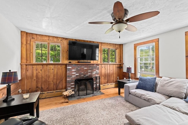 553 Center St, Hanover, MA 02339 - living area with wooden walls, wood finished floors, healthy amount of natural light, ceiling fan, and a fireplace