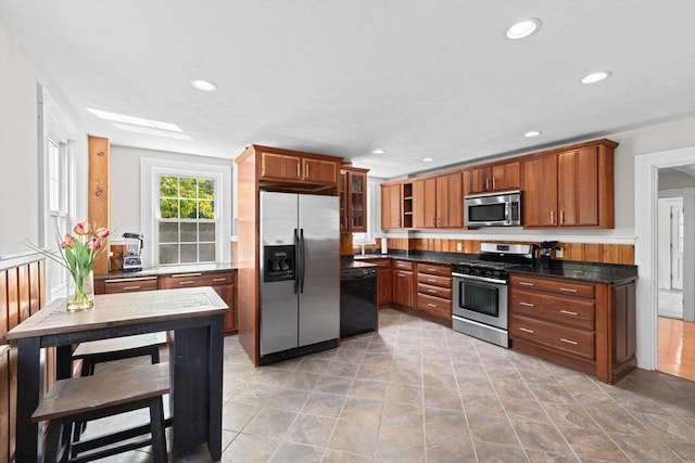 553 Center St, Hanover, MA 02339 - kitchen with appliances with stainless steel finishes, recessed lighting, glass insert cabinets, and brown cabinetry