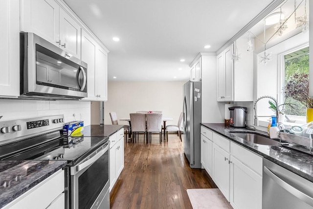 3 Bayberry Ln, Westfield, MA 01085 - kitchen featuring appliances with stainless steel finishes, a sink, white cabinets, dark wood-style floors, and tasteful backsplash