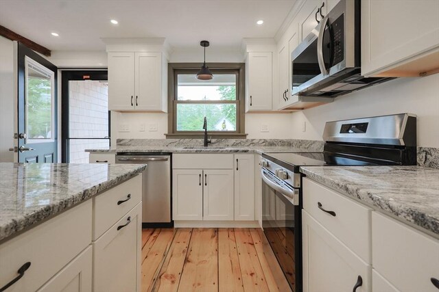 649 S Main St, Raynham, MA 02767 - kitchen featuring appliances with stainless steel finishes, a sink, light wood-style flooring, white cabinetry, and recessed lighting