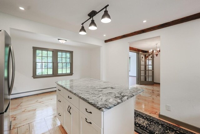 649 S Main St, Raynham, MA 02767 - kitchen featuring a baseboard radiator, freestanding refrigerator, light wood-type flooring, white cabinets, and light stone counters