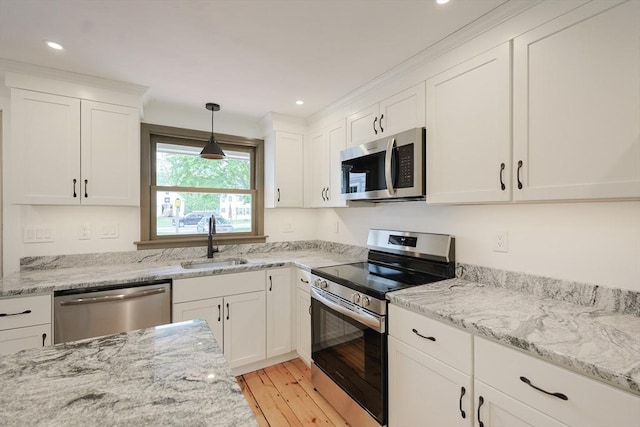649 S Main St, Raynham, MA 02767 - kitchen with appliances with stainless steel finishes, a sink, light wood-type flooring, white cabinets, and light stone countertops