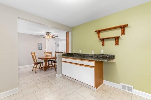 kitchen with ceiling fan and white cabinets