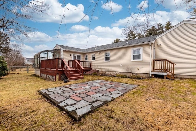 back of house featuring a wooden deck and a lawn