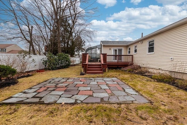 exterior space with a wooden deck, a lawn, and a patio