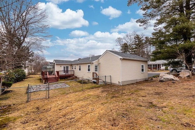 rear view of house featuring a deck and a yard