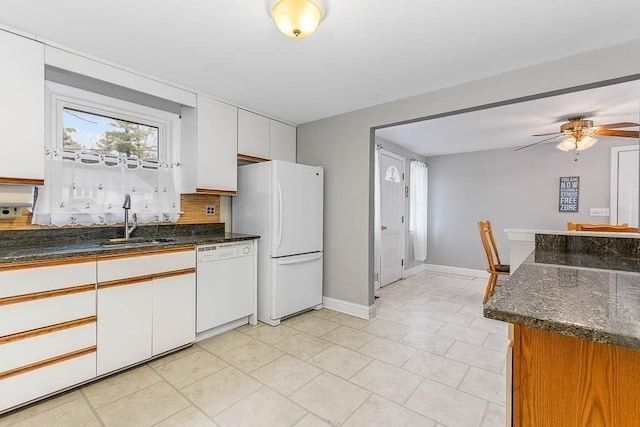 kitchen featuring white appliances, white cabinets, tasteful backsplash, sink, and ceiling fan