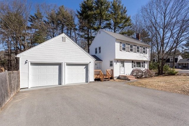 colonial-style house featuring a garage and fence